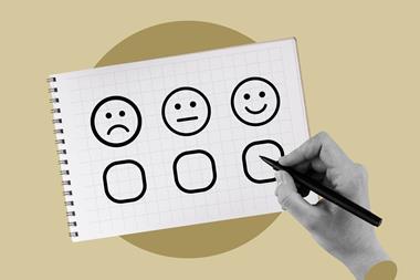 Hand filling in survey checking a happy face