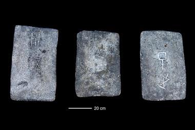 Photograph of three tin ingots samples with engravings on them