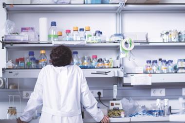 Female scientist in laboratory looking at shelves
