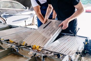 Technicians fitting batteries into an electric vehicle