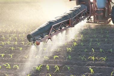 Tractor spraying crop