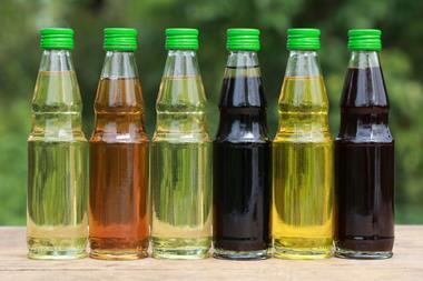 A photograph of different types of cooking oil in small bottles on a wooden table