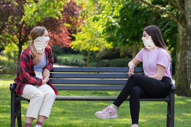 An image showing socially distanced friends wearing face masks