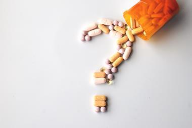 different drugs and health supplement pills in a question mark poured from a medicine bottle