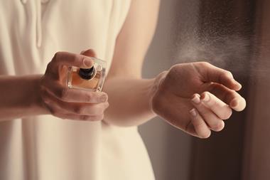 A woman applying perfume