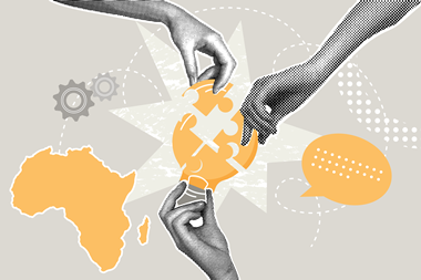 Hands building a lightbulb puzzle with the Africa map next to it