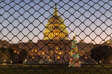 A picture taken during the sunrise over the United States Capitol Building and the Capitol Christmas Tree, now fenced off from the public during the government shutdown.
