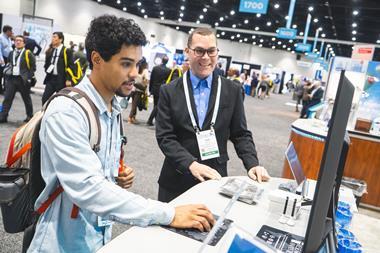 Two attendees at the Pittcon conference working around around a computer