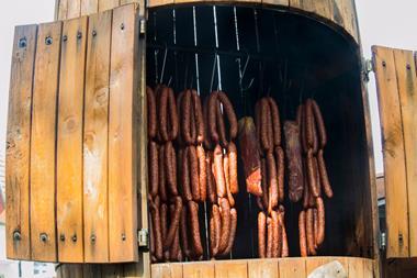 A photograph of meat in a smokehouse