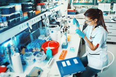 Image of a female scientist sat down, working in a biological lab
