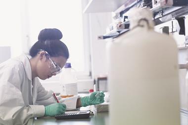 Female scientist in laboratory doing calculations