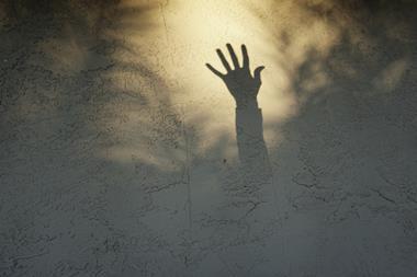 An image showing a shadow of a hand asking for help