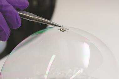 An ultra-lightweight solar cell is placed on the surface of an ordinary soap bubble