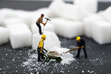 An image showing small human figurines working with blocks of sugar