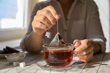 Woman taking teabag out of cup