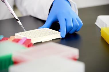 Scientist pipetting liquid into vials