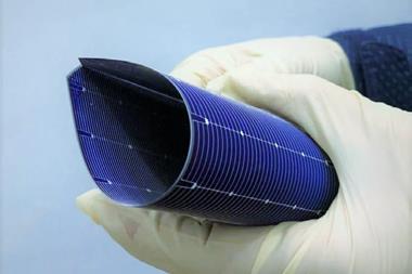 Hands in latex gloves bending a solar cell