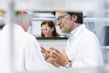 Two scientists talking in a laboratory environment.