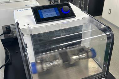 A a modern piece of technology featureing a small control screen above a clear viewing window onto a fast moving piece of machinery