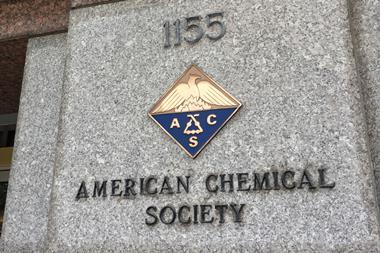 A sign and a crest on a marble building for the American Chemical Society
