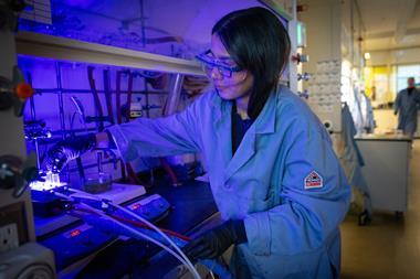 A researcher is at a fume hood setting up a reaction using LED lamps