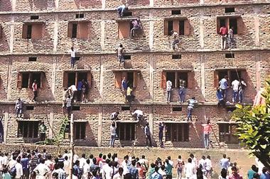 Relatives climbing exam building to help students pass exams, in Bihar, India, March 2015