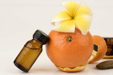 A photograph of orange peel and a bottle of essential oil