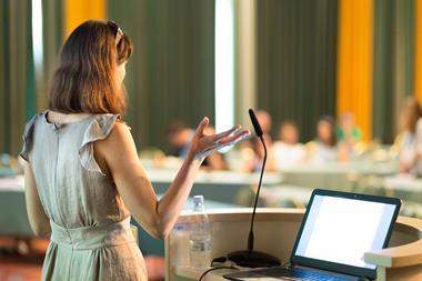An image showing a female speaker at a conference