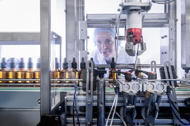 An image showing a woman in a pharmaceutical factory