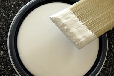 A photograph of a paintbrush and a tin of paint