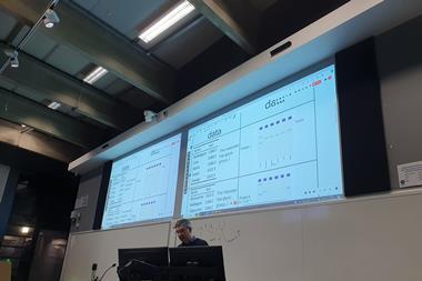 Man presenting with two big screens behind