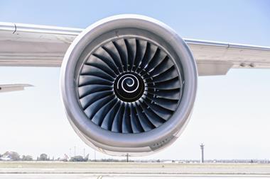 A photo of a single jet engine hanging under the wing of a commercial airplane
