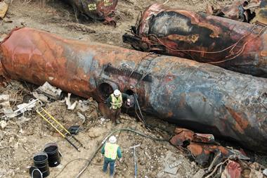 Aerial shot of two workers among some severely burnt rail tank cars