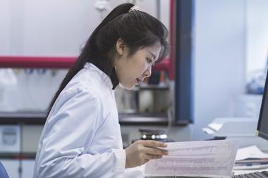 Female scientist reading documents in lab