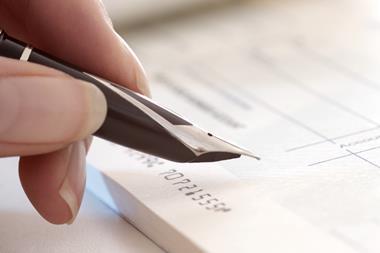 Picture of a a person holding a pen in their hand ready to write a cheque