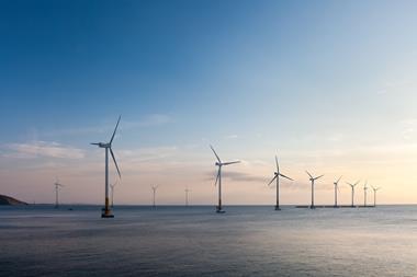 Landscape photo of an offshore wind farm just before dusk