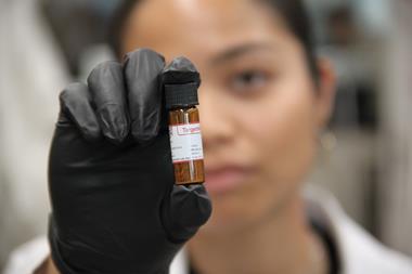 Denise Catacutan with a glass vial