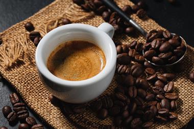 A cup of espresso with some coffee beans