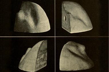 A black and white image from an old book of a smooth object that has three flat sides at 90 degrees to each other and a round lumpy fourth side