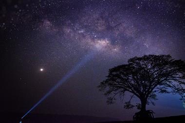 A photo showing the night sky with the Milky Way, Venus and a torch beam