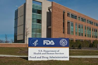 FDA Building 21 stands behind the sign at the FDA campus main entrance and houses the Center for Drug Evaluation and Research.