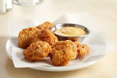 A photo of some battered artificial chicken bites with some sauce