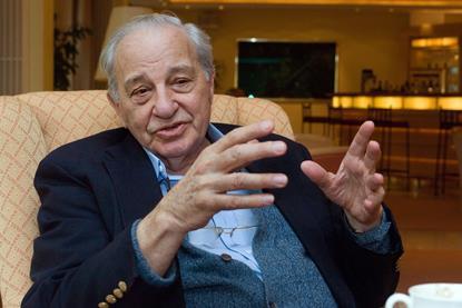 Rudolph Marcus sitting in an armchair gesturing with his hands as he speaks