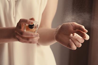 A woman applying perfume