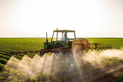 Tractor spraying soybeans
