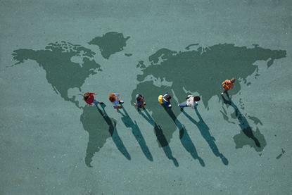 Young people walking away from the US on a large map of the world