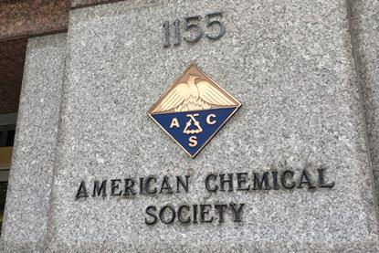 A sign and a crest on a marble building for the American Chemical Society