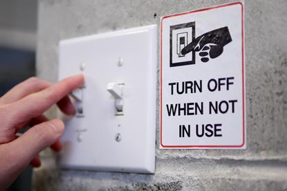 Hand on switch and "turn off when not in use" sign