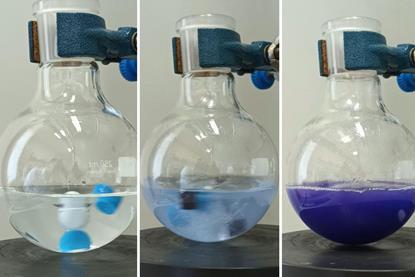 Three glass flasks showing a colour change in a reaction from clear to light blue to purple