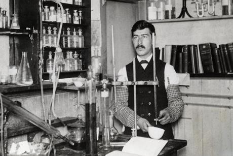 An old black and white photo of Moses Gomberg working in his lab
